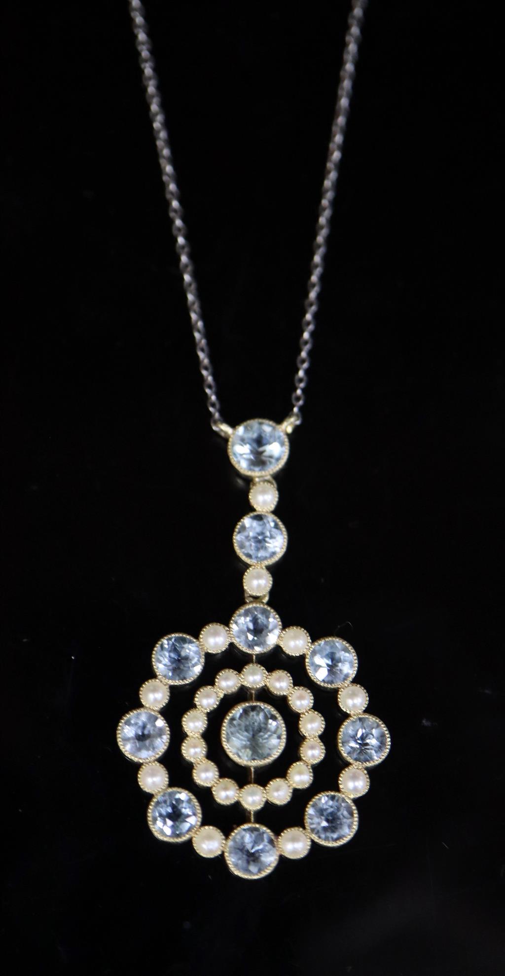 An Edwardian 15ct gold, aquamarine and seed pearl set circular drop pendant necklace,